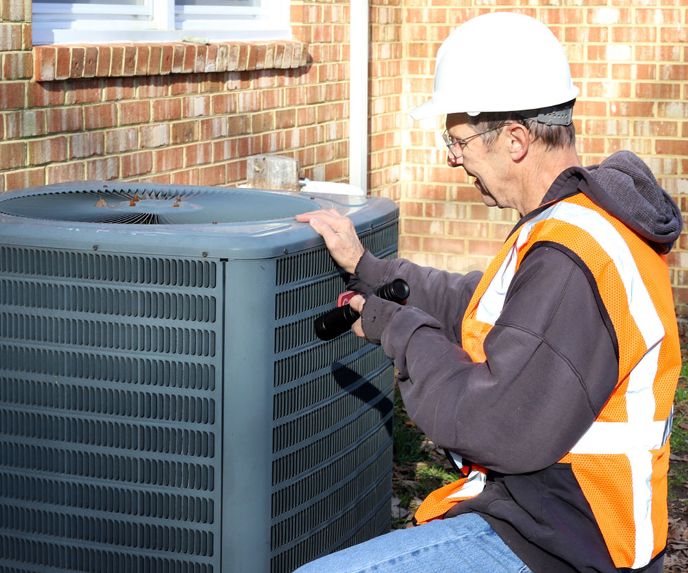 HM-4 Home inspection of central air unit by a maintenance worker